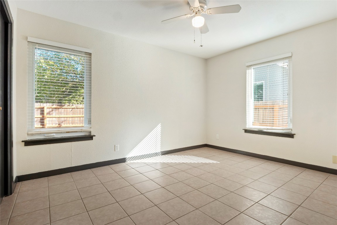 904 Plateau Circle, Unit A Austin, TX 78745 - Photo 18 of 26 an empty room with windows and fan