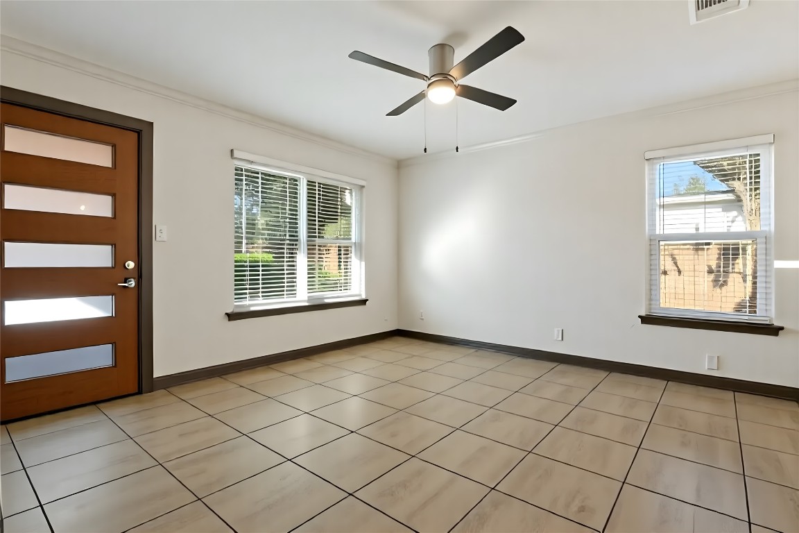 904 Plateau Circle, Unit A Austin, TX 78745 - Photo 5 of 26 a view of an empty room with a window and a ceiling fan
