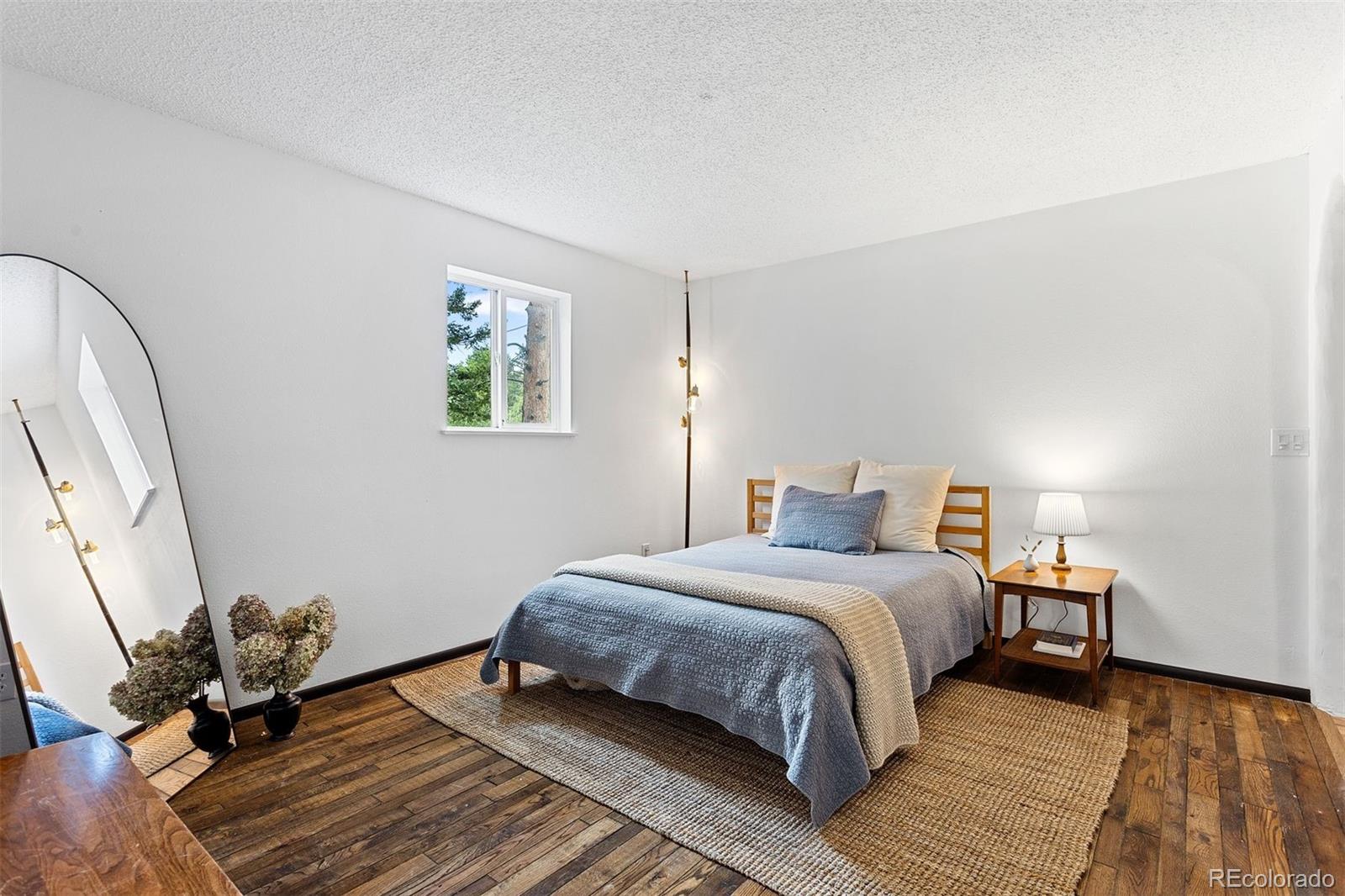 616 South Pine Drive Bailey, CO 80421 - Photo 25 of 50 a bedroom with a bed and wooden floor