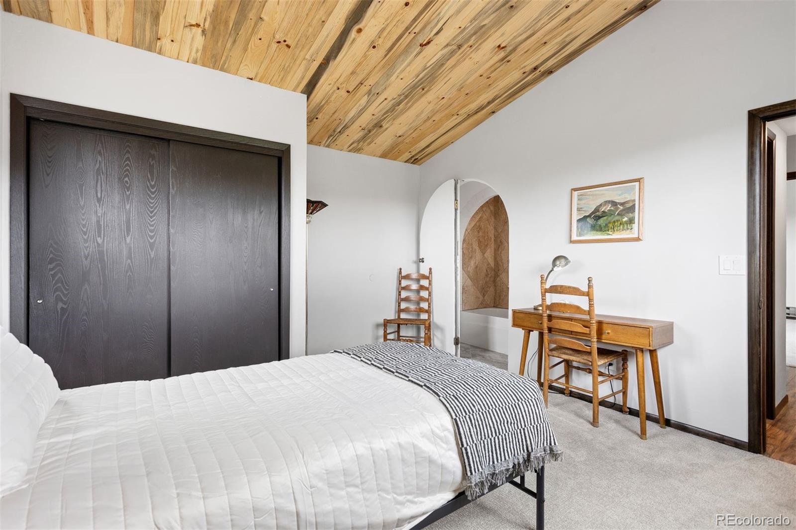 616 South Pine Drive Bailey, CO 80421 - Photo 29 of 50 a bedroom with a bed and a table in it