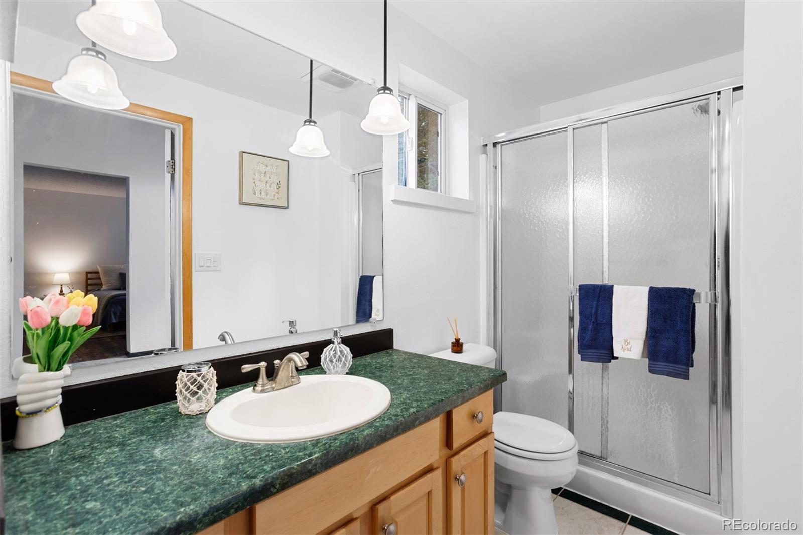 616 South Pine Drive Bailey, CO 80421 - Photo 35 of 50 a bathroom with a granite countertop sink and a mirror