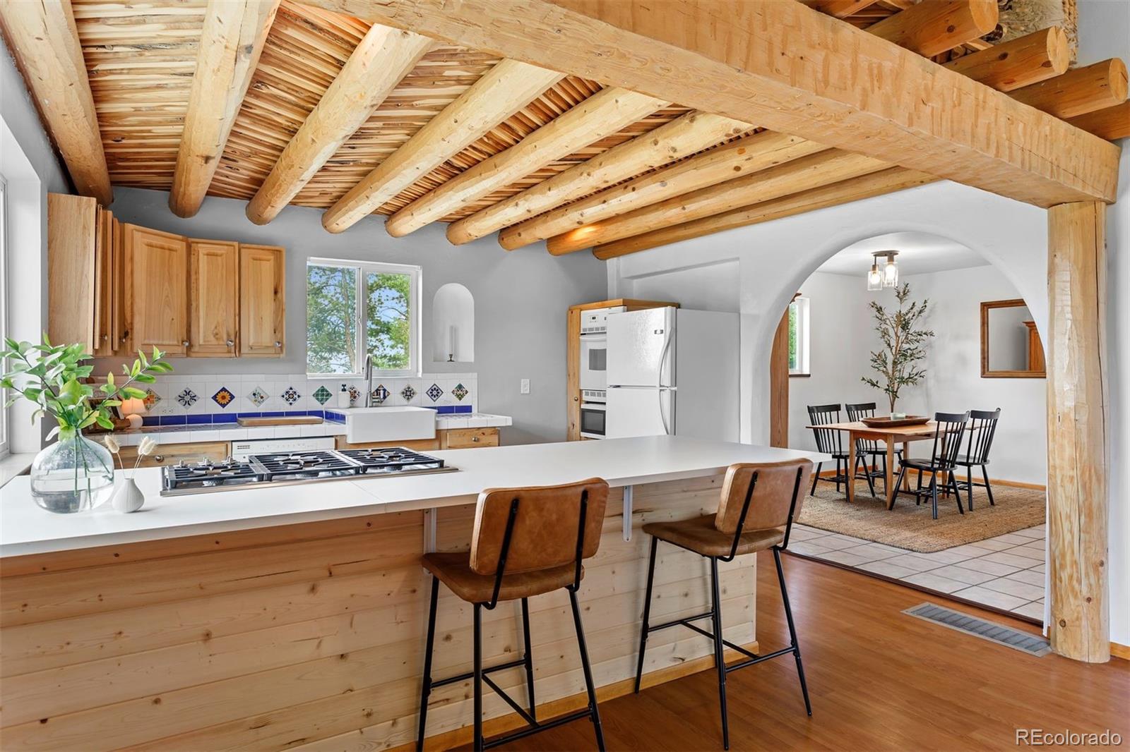 616 South Pine Drive Bailey, CO 80421 - Photo 6 of 50 a kitchen with a table chairs and a stove