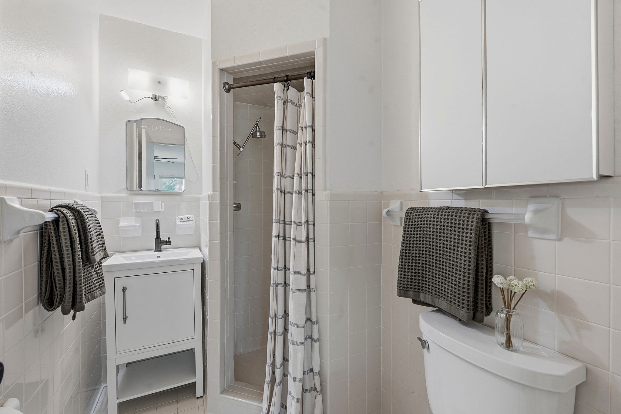 900 Stark Street Austin, TX 78756 - Photo 15 of 25 An updated bathroom features clean tiled walls and a functional vanity.