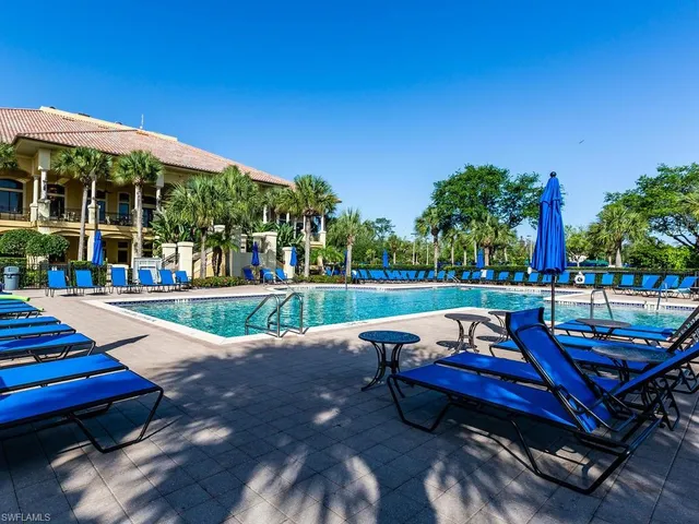 a view of a swimming pool with lounge chairs in patio