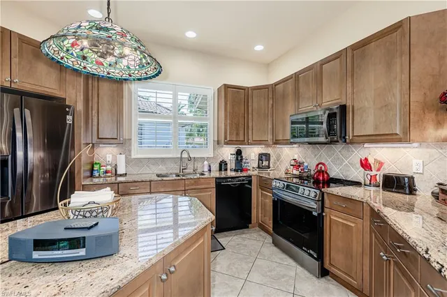 a kitchen with kitchen island granite countertop stainless steel appliances a sink stove top oven and cabinets
