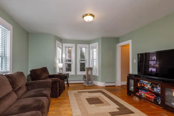 a living room with furniture a flat screen tv and a window