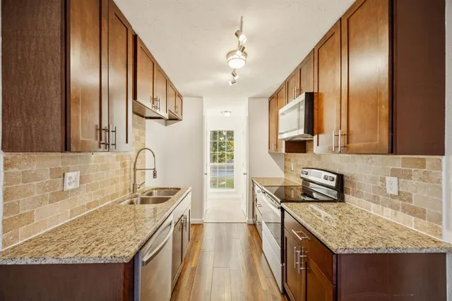 a kitchen with stainless steel appliances granite countertop a sink stove and refrigerator