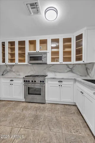 a kitchen with stainless steel appliances granite countertop a stove and a refrigerator