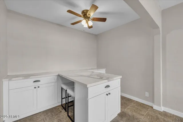 a kitchen with a refrigerator and white cabinets