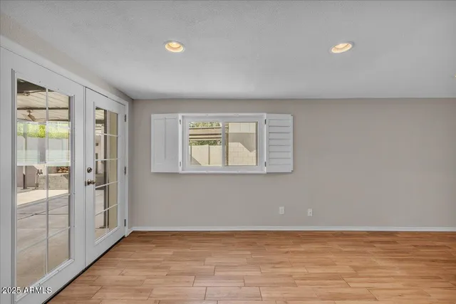 a view of empty room with wooden floor and fan