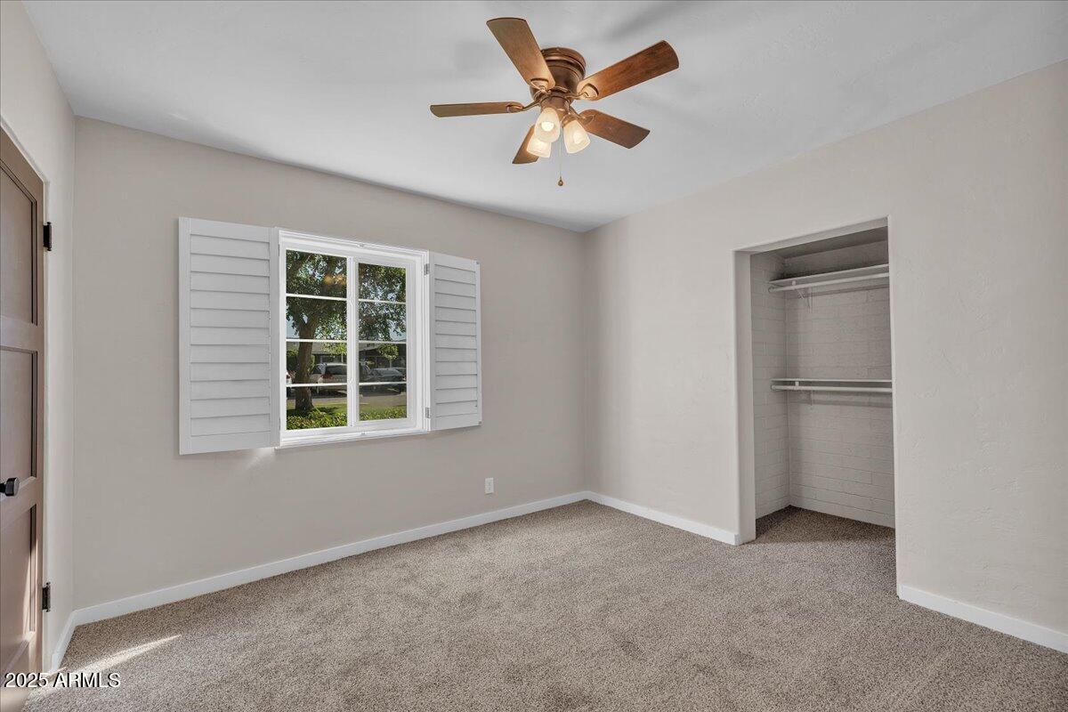 4632 North 14th Street Phoenix, AZ 85014 - Photo 17 of 46 an empty room with a window and a ceiling fan