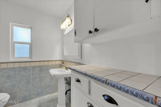 a bathroom with a sink a toilet and mirror