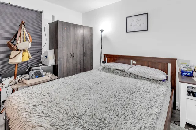 a bedroom with a bed and a mirror on dresser