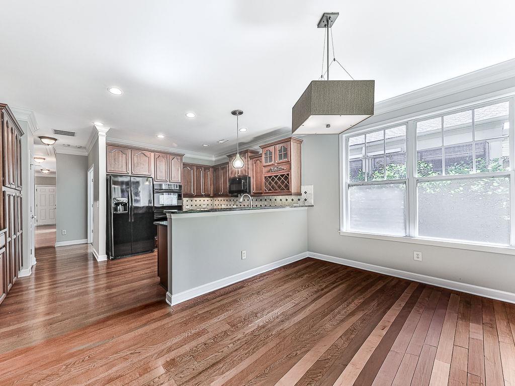 626 Laurel Crossing Canton, GA 30114 - Photo 21 of 77 a kitchen with stainless steel appliances granite countertop a stove top oven a sink with wooden floors and cabinets