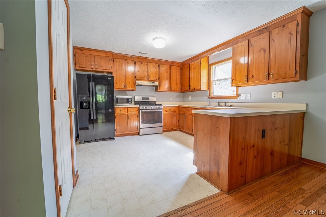 2263 Pony Farm Road Maidens, VA 23102 - Photo 12 of 27 a kitchen with stainless steel appliances granite countertop a stove top oven a sink dishwasher and wooden cabinets with wooden floor