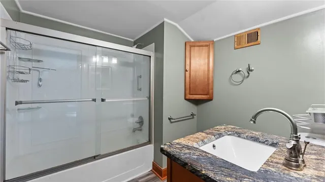 a bathroom with a granite countertop sink a shower and a mirror