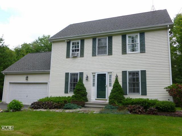 a front view of a house with a yard and plants