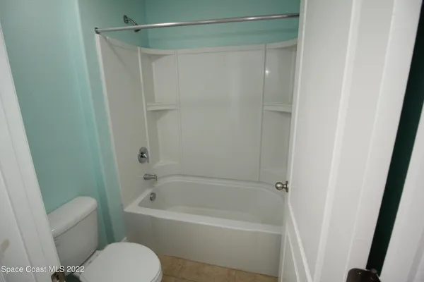 a white bath tub sitting next to a white toilet and sink