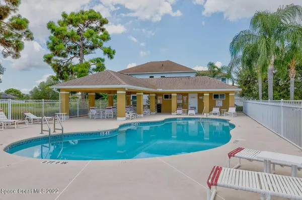 a view of house with swimming pool and outdoor seating