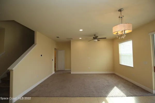 a view of a livingroom with a chandelier furniture and windows