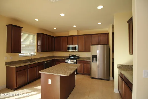 a kitchen with a sink a refrigerator and a stove