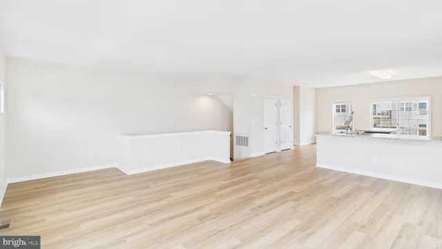 a view of a kitchen with wooden floor and a sink