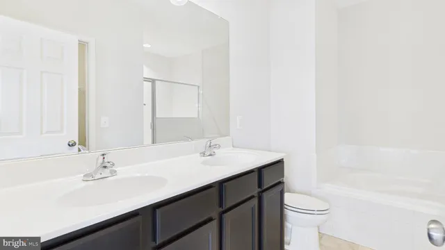 a bathroom with a sink a toilet a shower and a mirror