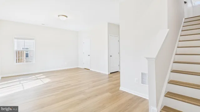 a view of an empty room with wooden floor and entryway