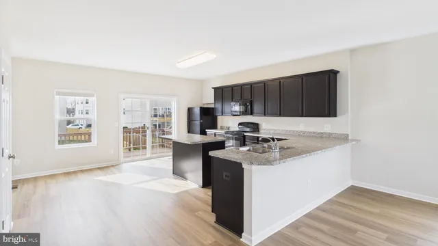 a kitchen with granite countertop a sink stove and cabinets