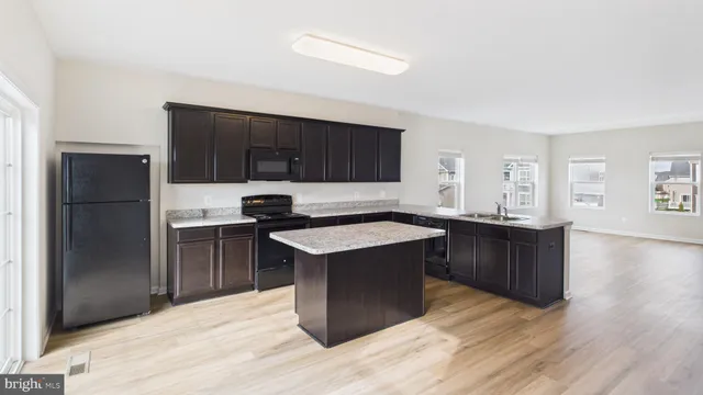 a kitchen with a refrigerator and a stove top oven