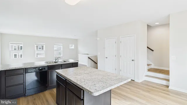 a kitchen with a granite countertop sink and cabinets