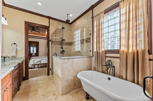 a bathroom with a granite countertop tub sink a mirror and a shower