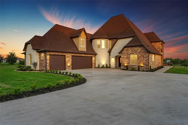 a front view of a house with a garden and yard