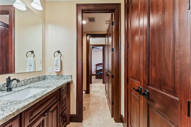 a en suite bathroom with a granite countertop sink and a mirror