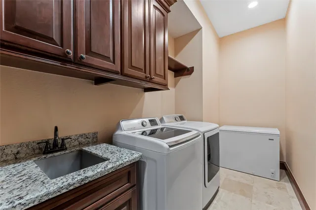 a kitchen with granite countertop cabinets washer and dryer