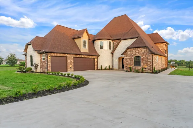 a front view of a house with a garden and yard