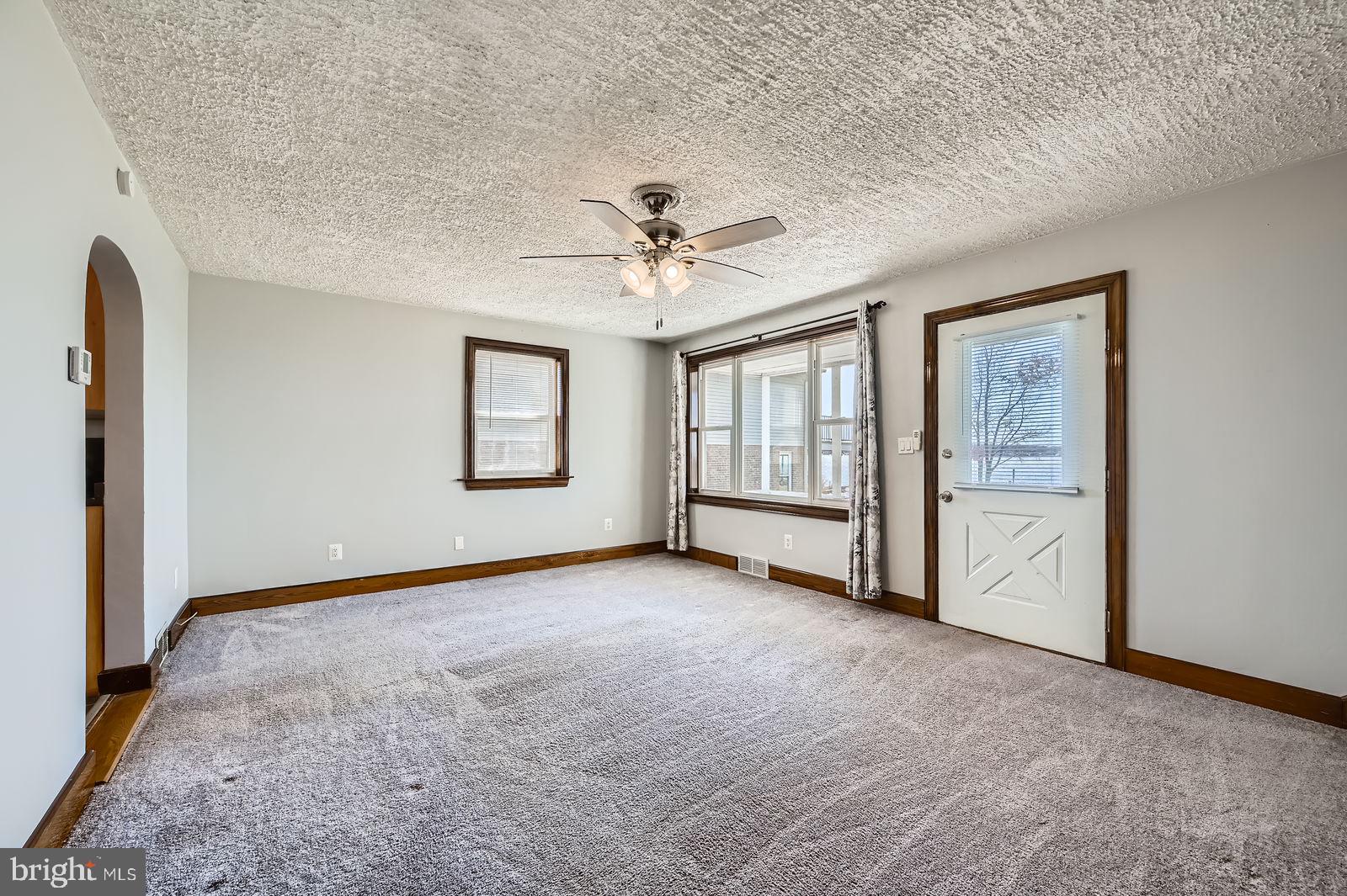 1004 Thompson Boulevard Baltimore, MD 21221 - Photo 22 of 48 an empty room with windows and ceiling fan