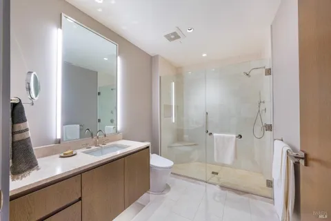 a bathroom with a double vanity sink toilet mirror and shower