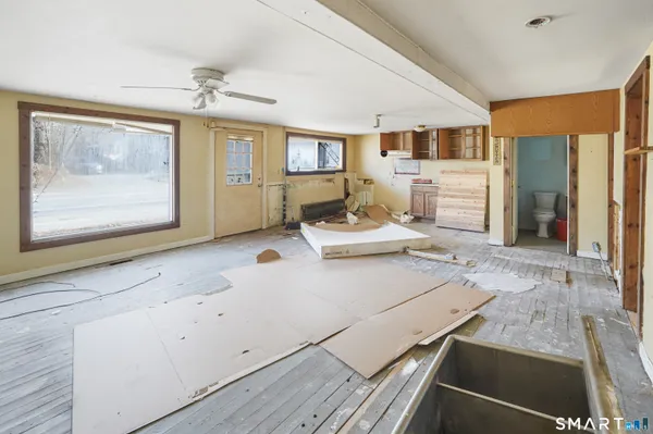 a living room with stainless steel appliances kitchen island granite countertop furniture and a fireplace