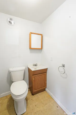 a bathroom with a toilet a sink and mirror
