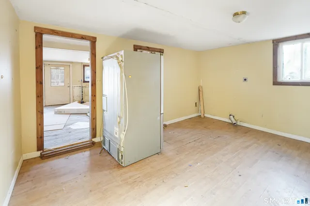 an empty room with window and bathroom