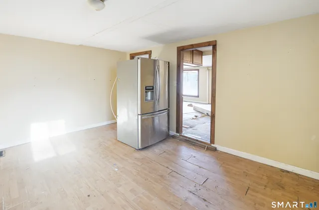 a view of empty room with wooden floor and window