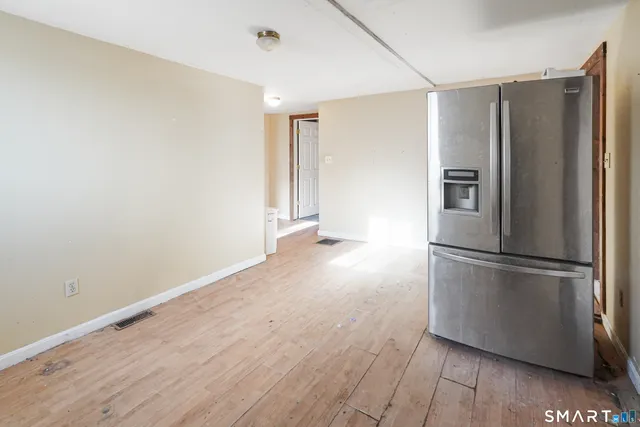 a view of a kitchen with a refrigerator and wooden floor