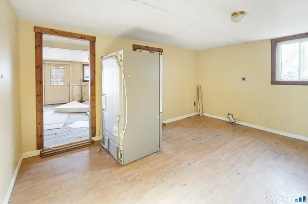 an empty room with window and bathroom