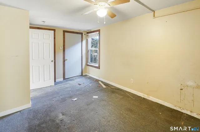 a view of a room with a ceiling fan and a window