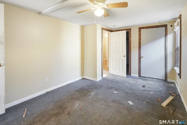 an empty room with a ceiling fan and a bathroom view