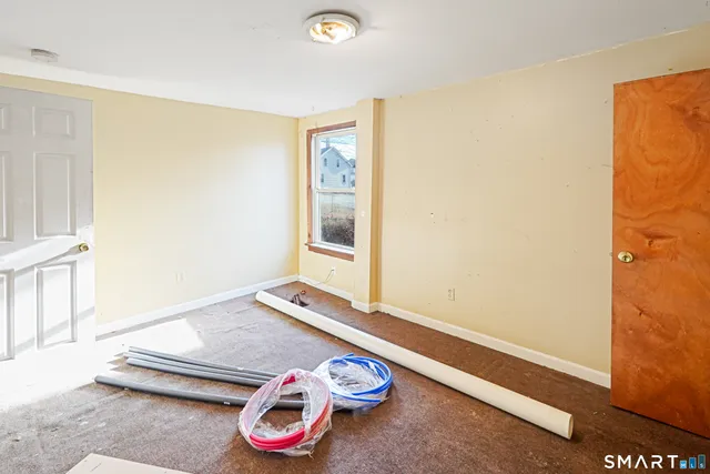 a room with a white bed and a wooden floor