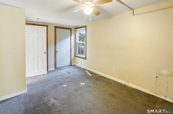 a view of a room with a ceiling fan and a window