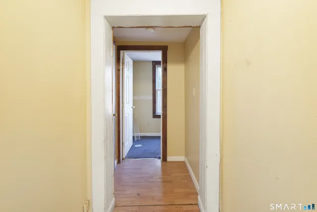 a view of a hallway with wooden floor