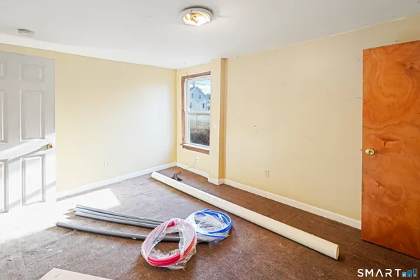 a room with a white bed and a wooden floor
